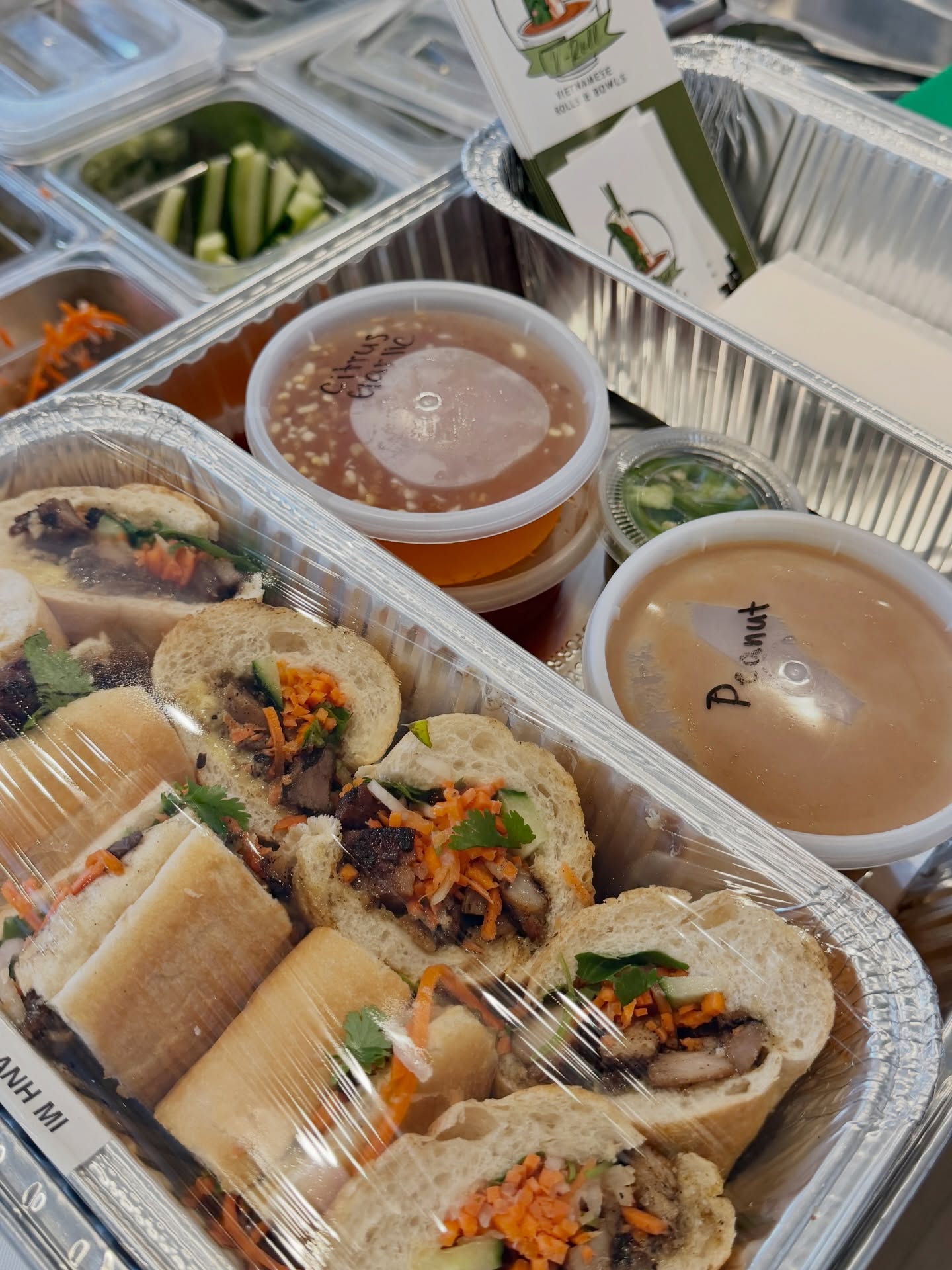 Overhead view of foil catering trays and sauce cups packed for pickup