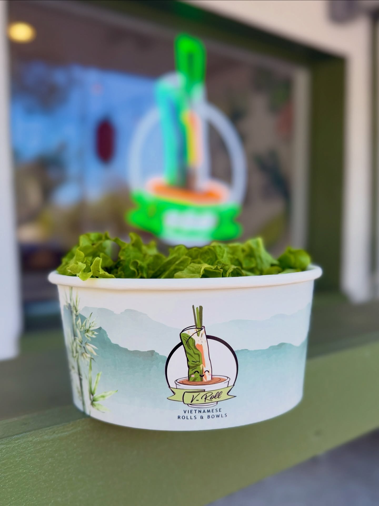 A V-Roll branded bowl of greens on the front window counter