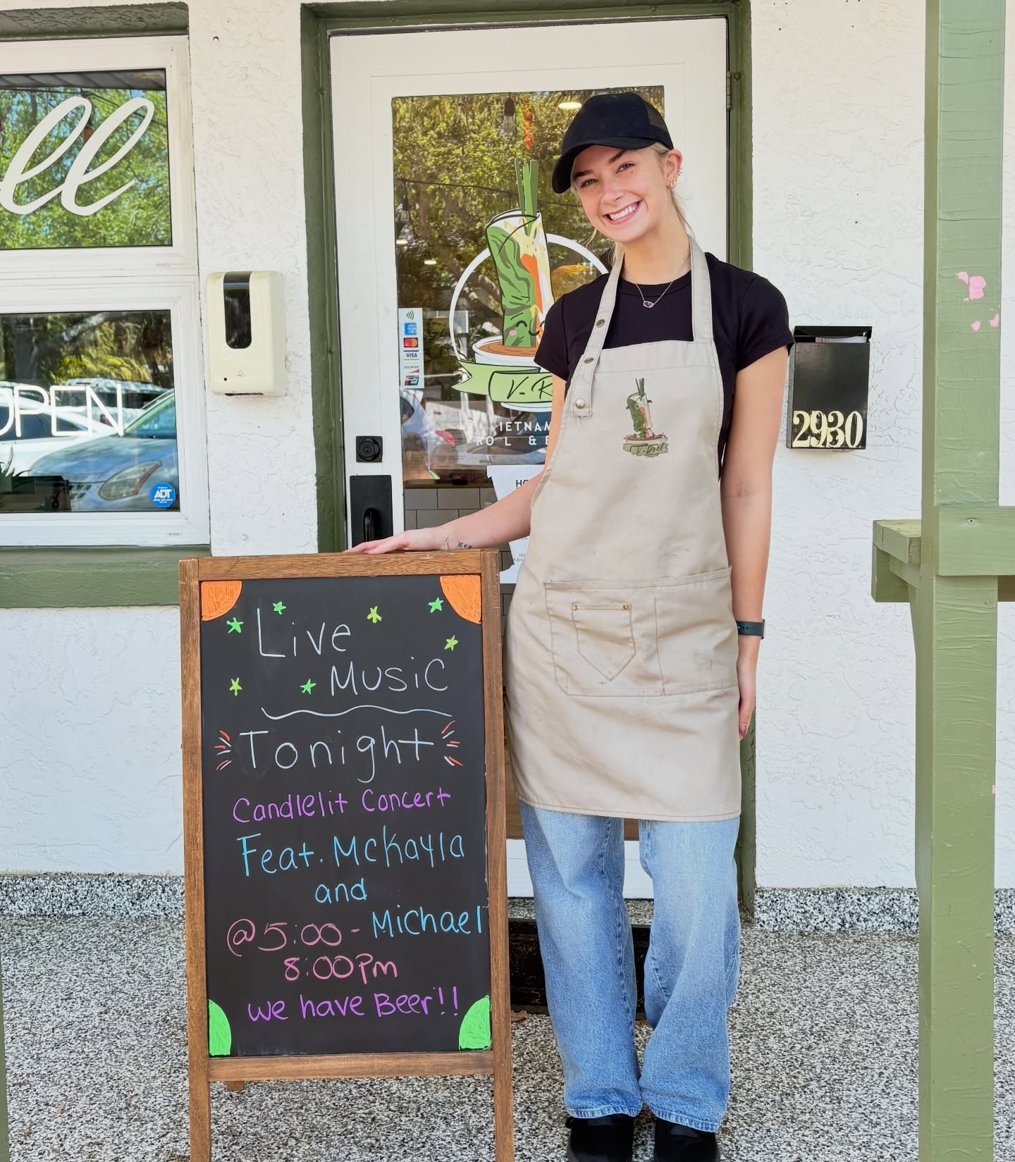 A V-Roll team member beside the Live Music Tonight chalkboard at the front door