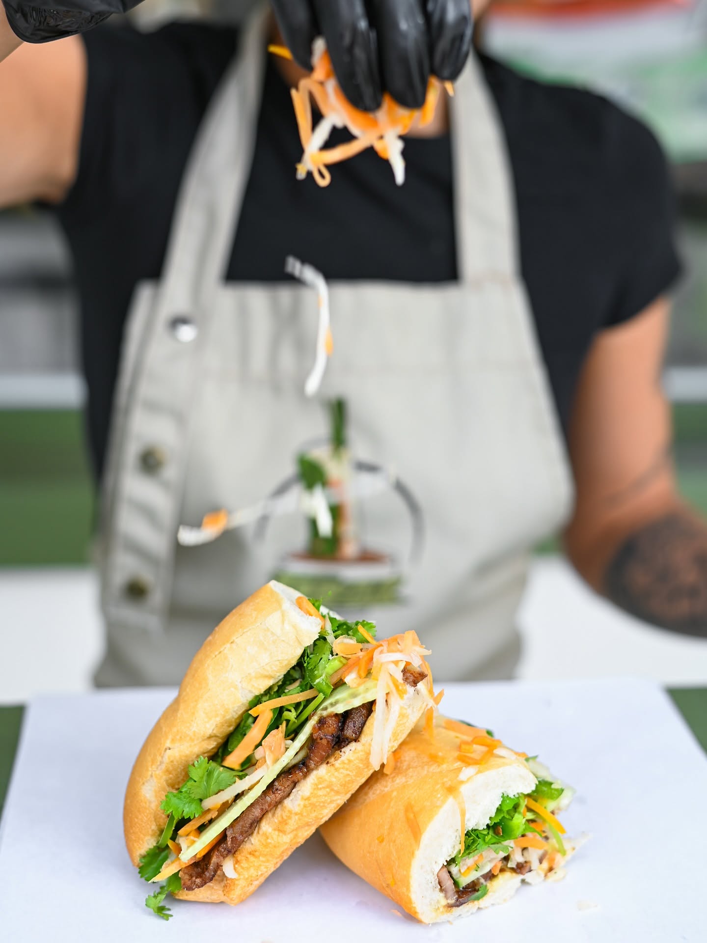 A cut bánh mì held up over the counter