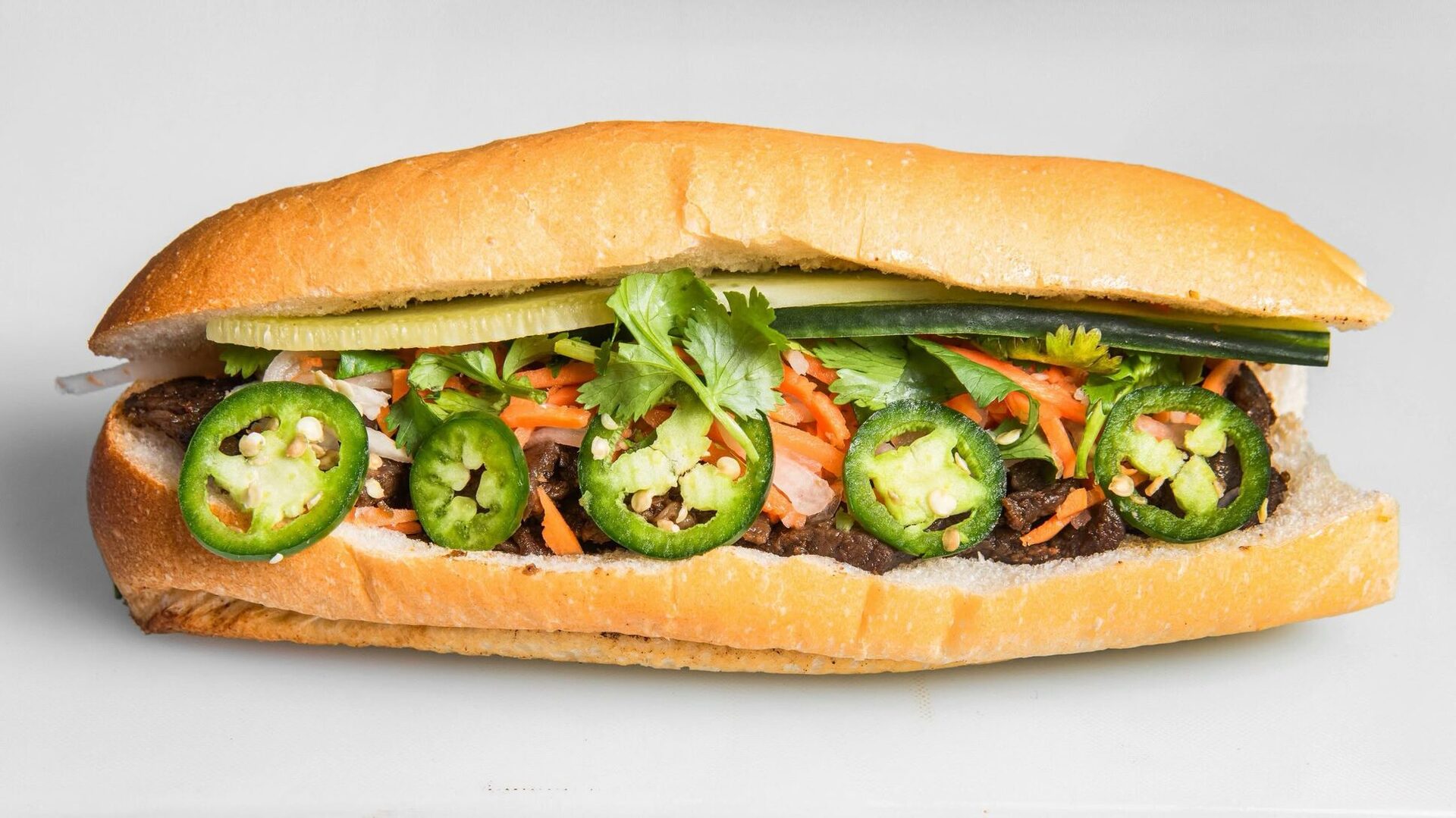 V-Roll Bánh Mì with sliced jalapeño, cilantro, cucumber and pickled carrot